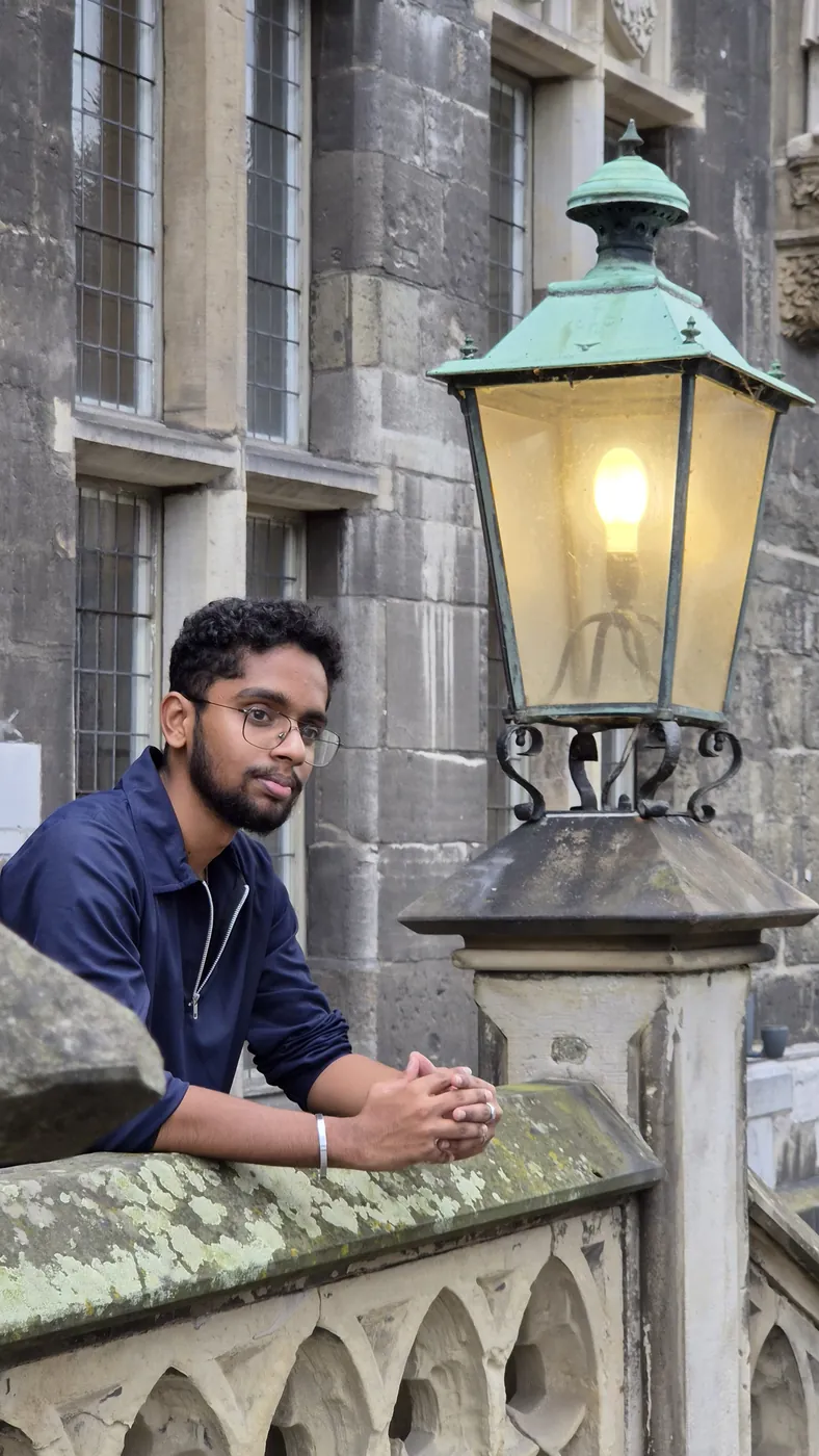 Darshan leaning on a stone balustrade beside an old lantern