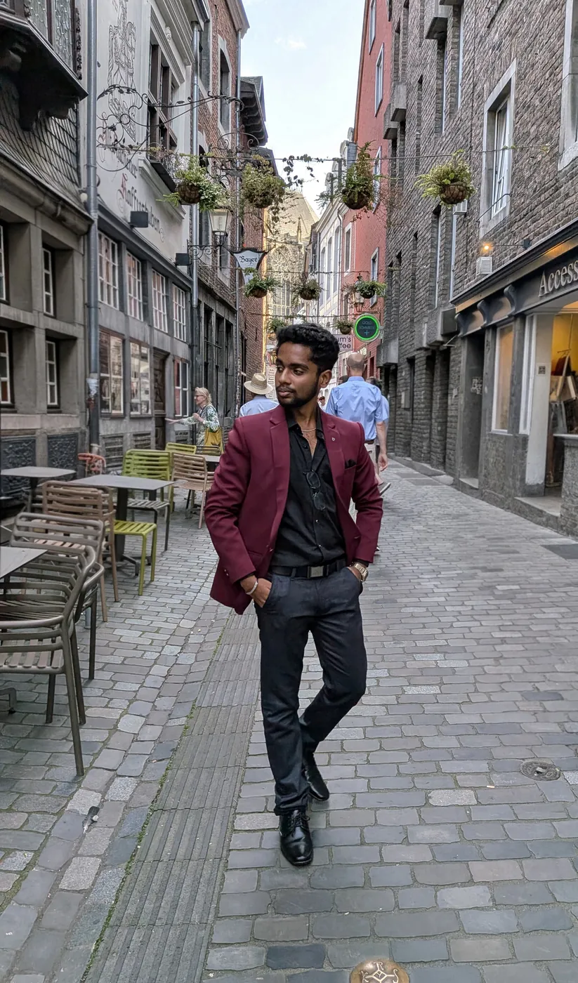 Darshan in a maroon blazer walking down a cobbled street