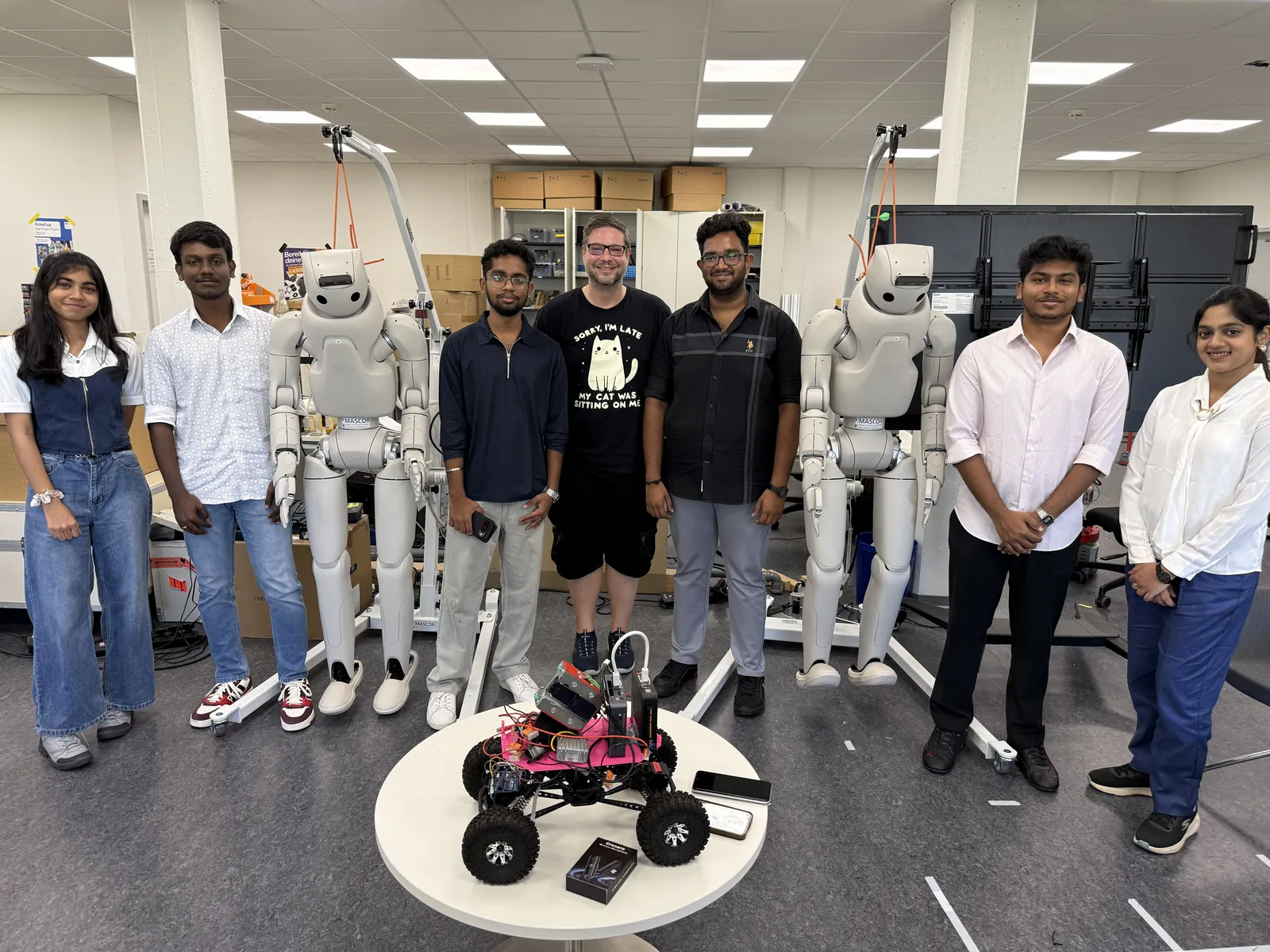 Darshan with podcast guest Marcel Stüttgen and fellow students in a robotics lab