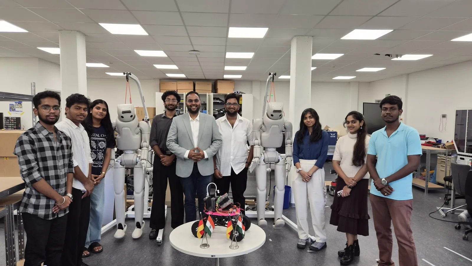 Darshan with podcast guest Raj Vangapandu and fellow students in a robotics lab